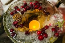 a lovely Christmas ice lantern with evergreens, cranberries and a pinecone is a cool way to illuminate your outdoor space