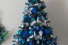 a lovely tabletop Christmas tree with silver, bold blue and navy ornaments and butterflies is an amazingly chic and bold idea