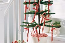 a potted Christmas tree with candy canes and a vase with greenery and candy canes will make your space look festive and fun