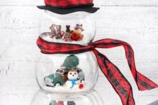 a pretty snowman of fish bowls with mini toy scenes inside, with a plaid scarf and a top hat is a lovely decoration for winter