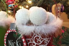 a red snowflake bucket with fluffy snowballs and a sign is a lovely decoration for Christmas and it looks very fun