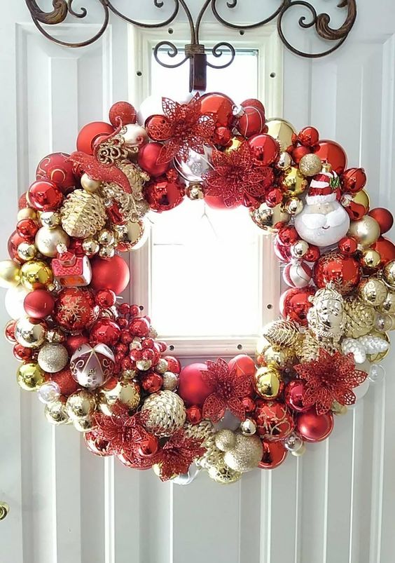 a shiny Christmas wreath fully made of ornaments, in gold, silver and red, of various sizes and looks