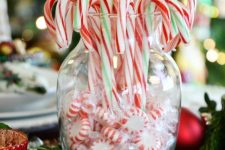 a simple edible decoration of a vase with peppermints and candy canes and greenery around is a stylish idea for holiday decor