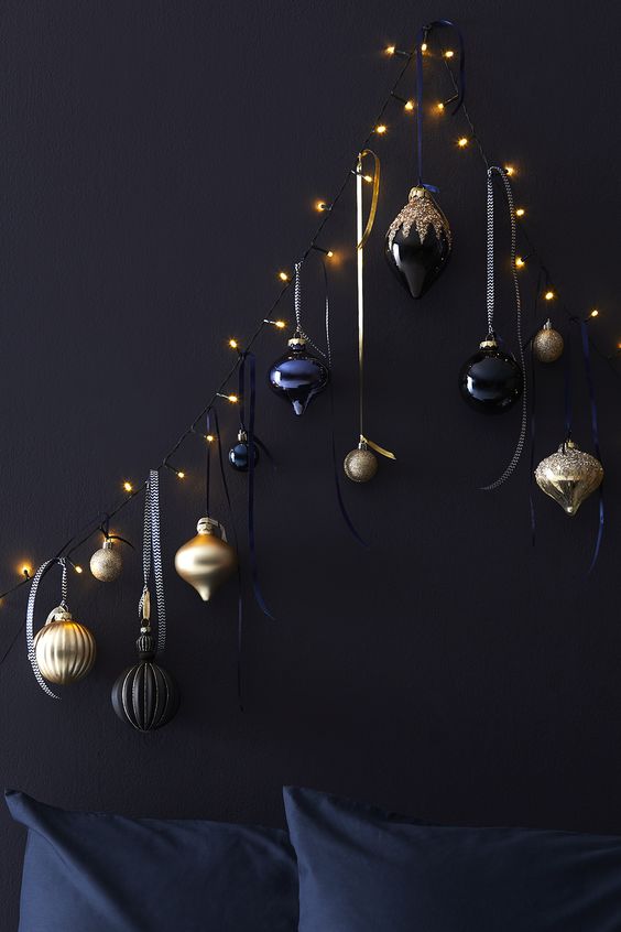 A unique Christmas tree of lights and black, navy and gold ornaments hanging on them is a lovely space saving idea