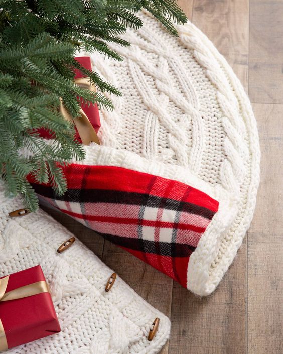 a white braided knit Christmas tree skirt with bold red plaid lining is a chic and cool idea for a traditional Christmas tree