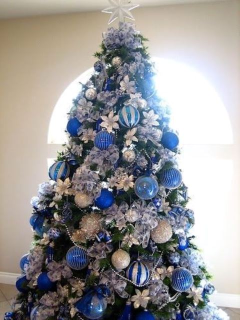 bold Christmas tree decor with silver, blue and navy ornaments, fabric blooms and a star topper is a cool idea for holidays