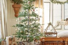 farmhouse Christmas styling with baskets, a wooden sleigh with gifts, an evergreen garland, pillar candles and vases
