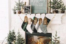 modern farmhouse Christmas decor with plaid stockings, gold bells, mini trees in baskets and crates and a house stand for firewood