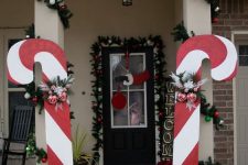 oversized candy canes with ornaments and fir branches will make your home entrance and make it look bold and cool