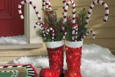 red boots with fir branches, berries and candy canes are amazing Christmas decor with a slight fun touch