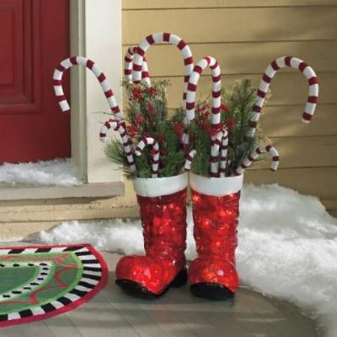 red boots with fir branches, berries and candy canes are amazing Christmas decor with a slight fun touch
