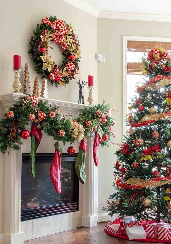 red, gold and green Christmas decor with stockings, a wreath and a tree with ribbons and ornaments