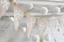 snowy Christmas mantel decor with a burlap runner, snowball garlands and snowy greenery is very chic and elegant