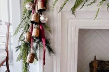 a beautiful Christmas garland of evergreens and greenery, oversized vintage bells, Christmas ornaments and a burgundy ribbon bow