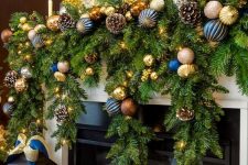 a colorful Christmas garland of evergreens, blue and gold ornaments, snowy pinecones is perfect for a mantel
