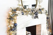 a glam Christmas mantel with a gold, silver and navy Christmas ornament garland and tall gold deer figurines is a chic idea to rock