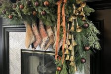 a gorgeous Christmas garland of evergreens, chocolate brown ornaments, large bells and printed stockings