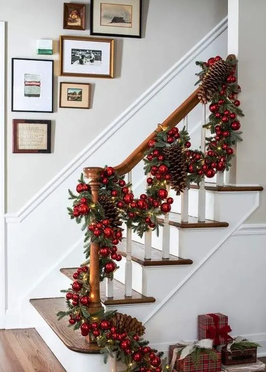 a gorgeous evergreen Christmas garland with red ornaments, lights and oversized pinecones will make a gorgeous statement in the space