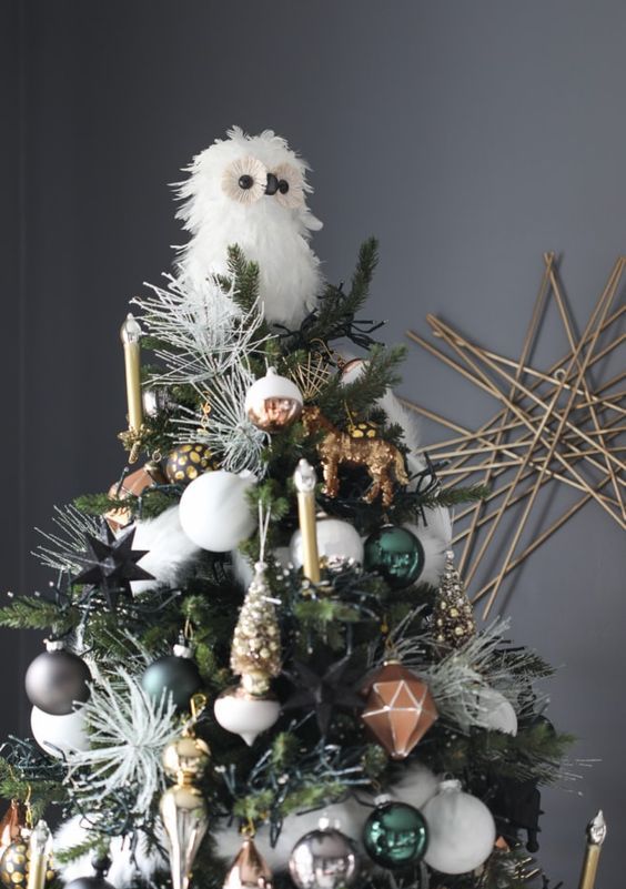 a gorgeous woodland Christmas tree with gilded candles, green, silver, white and copper ornaments, little animal figurines and a faux owl tree topper