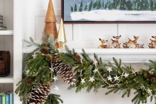 a pretty Christmas garland of evergreens, white stars, beads and snowy pinecones is a cool decoration for the mantel