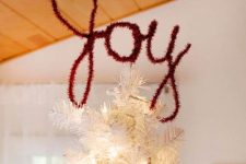 a white Christmas tree topped with a JOY topper made of bottle brush is a very modern and fresh solution