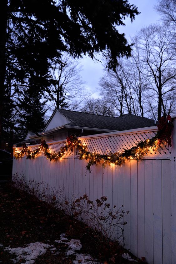 An evergreen and light garland covering the fence gives it a very holiday like and festive feel