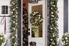 bright and festive Christmas front door decor with evergreen garlands and metallic ornaments, topiaries and candle lanterns