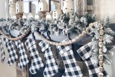 buffalo check stockings, flocked evergreens and wooden bead garlands for Christmas mantel decor