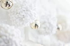 white pompom garlands with bells are very cozy and refined decorations for Christmas