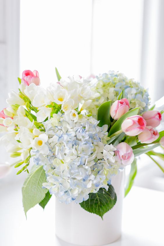 a beautiful and very simple spring flower arrangement of hydrangeas, daffodils, tulips in pastel shades is wow
