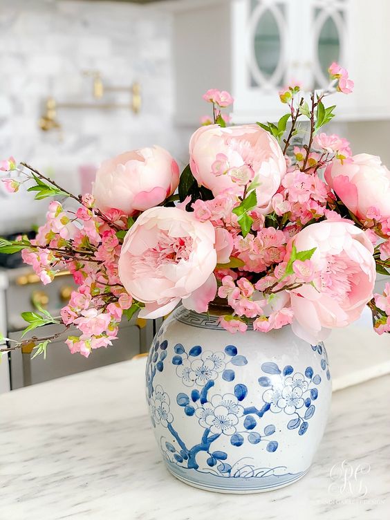 a blue floral vase with pink peonies and cherry blossom is a beautiful spring decor idea for a preppy space
