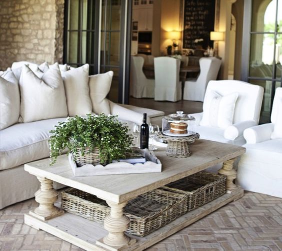 a chic farmhouse coffee table with basket trays under it to store some blankets, pillows and stuff like that