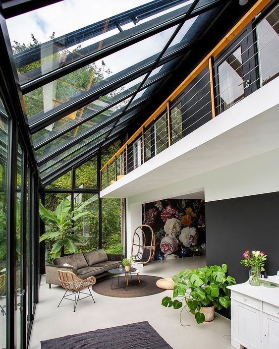 a contemporary sunroom with stylish modern furniture, potted greenery and rugs and lots of sunshine