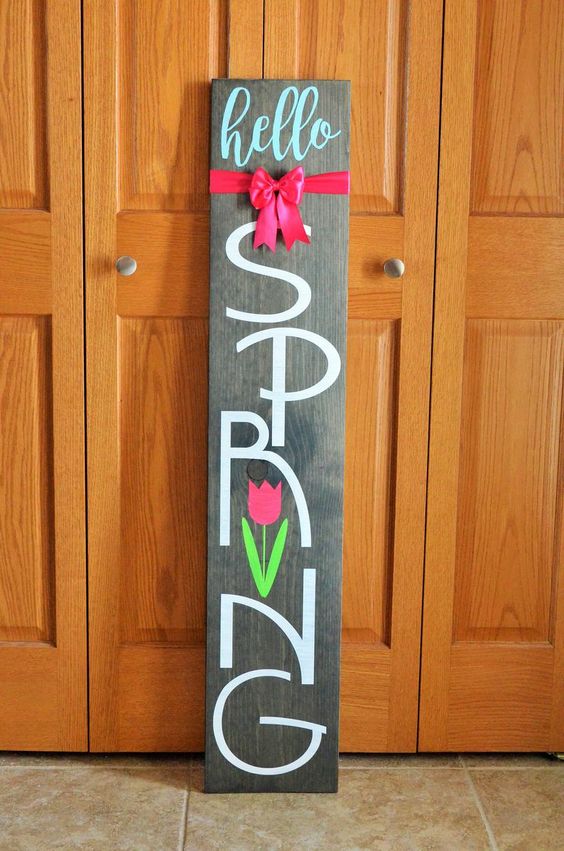 a dark stained wooden sign with a pink bow and a pink tulip is a lovely idea for outdoors