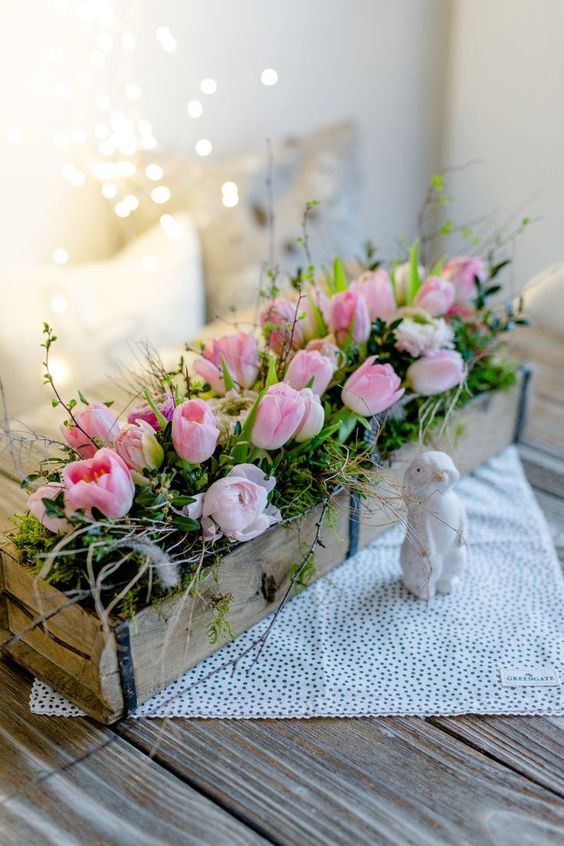a fabulous rustic arrangement of a wooden box, moss, greenery, pink tulips and some twigs is very fresh and cool