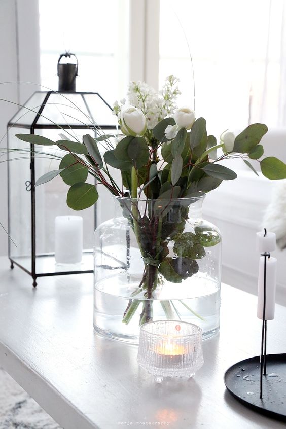 a large white vase with white blooms and eucalyptus is a classic flower arrangement that always works