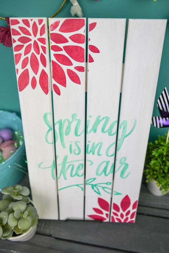 a painted wooden spring sign with green letters and red blooms is easy to make and very bright