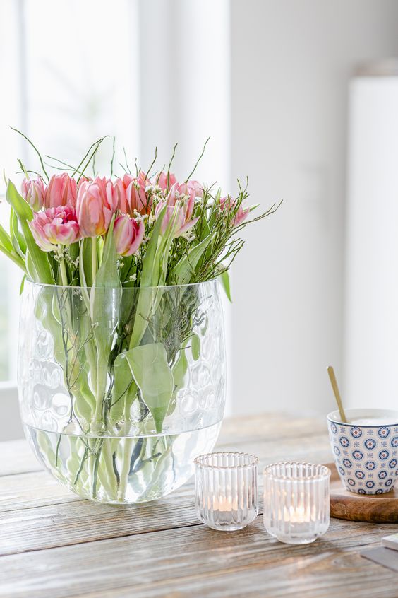 a tall vase with lots of pink tulips and willow is a fresh and easy spring flower arrangement to make yourself