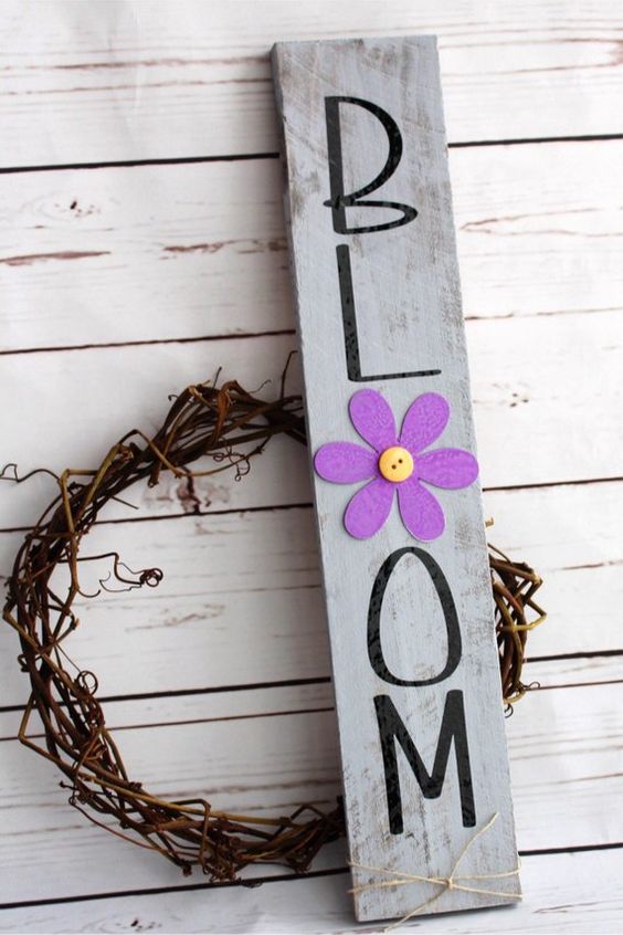 a vine wreath paired wiht a grey rustic sign with a bold purple bloom and black letters is a lovely idea