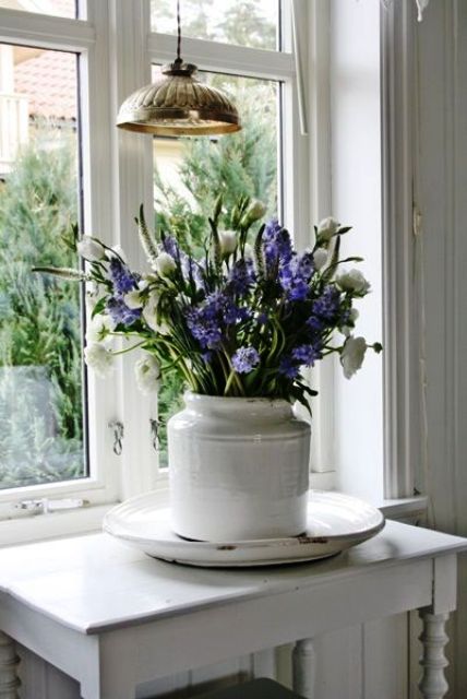 a white vase with white ranunculus and purple hyacinths is a lovely idea for a vintage rustic or Scandi space