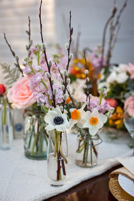 bottles and vases with willow, white blooms, pink and lilac blooms look fresh and spring-like
