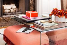 bright coral and red ottomans placed under an acrylic coffee table will be clearly seen and can be taken from there when needed