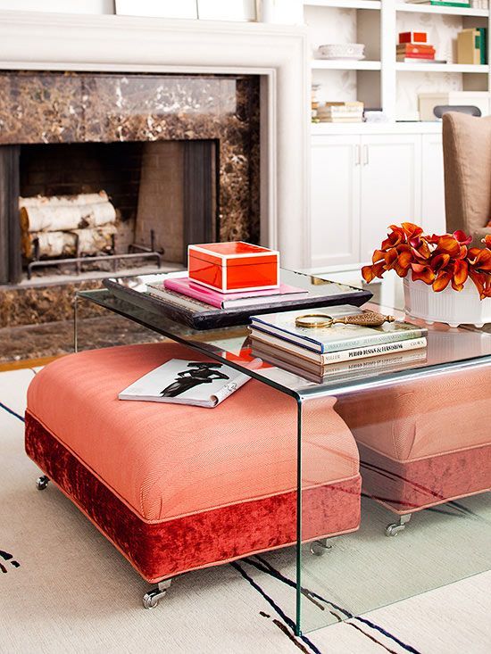 bright coral and red ottomans placed under an acrylic coffee table will be clearly seen and can be taken from there when needed