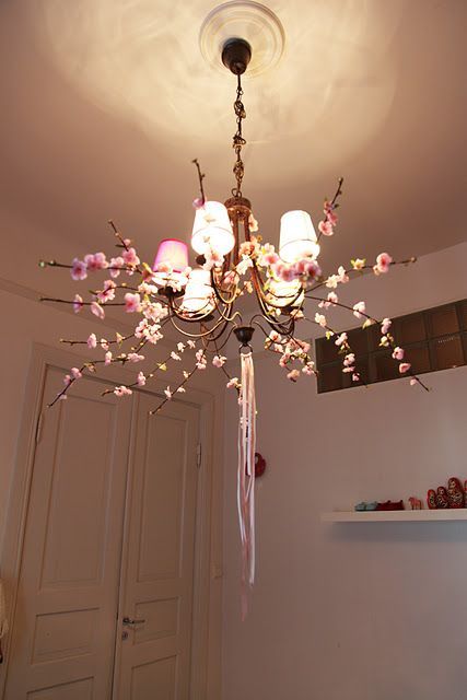 decorate your chandelier with silk blooming branches and ribbons to make it feel like spring