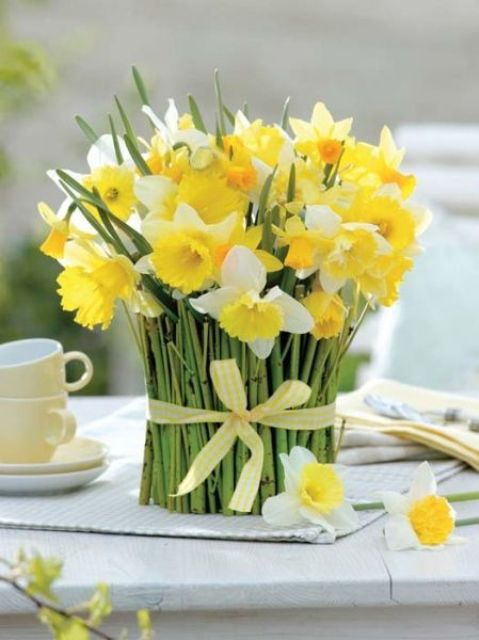 white and yellow daffodils wrapped with green stems and with a yellow ribbon is a pretty spring decor idea