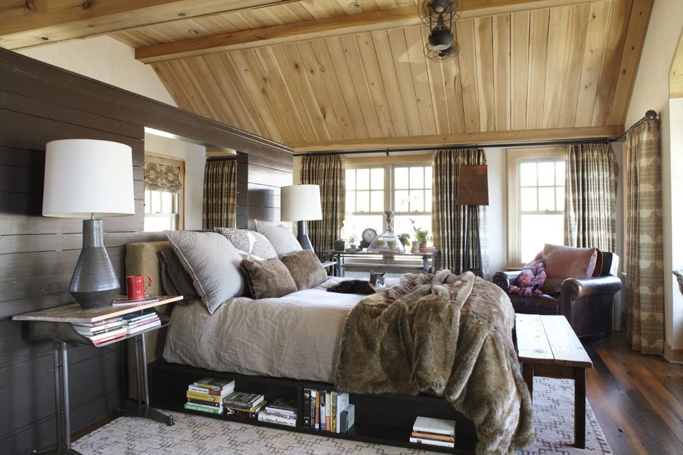 a cozy farmhouse bedroom with much wood, printed curtains and a bed with storage space (Dan Ruhland Designs LLC)