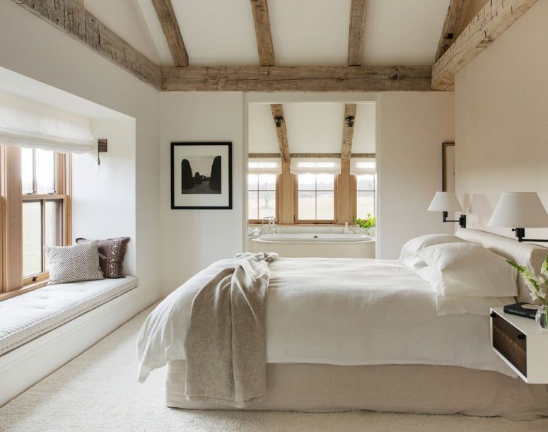 a contemporary farmhouse bedroom with weathered wood ceiling beams, neutral textiles and much natural light  (Finstad's Carpet One)