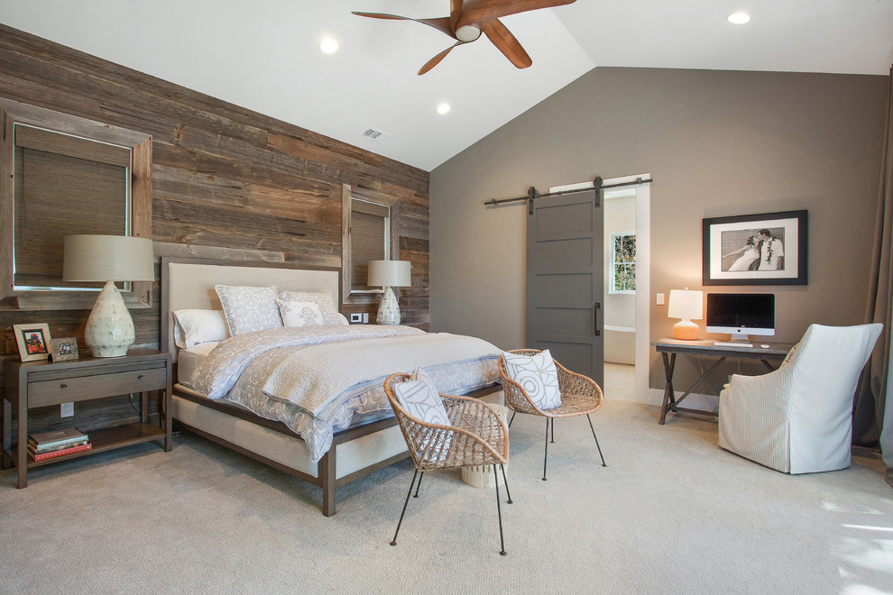 a contemporary meets farmhouse bedroom with a weathered wooden wall, rattan chairs, a sliding barn door  (LMK Interiors)