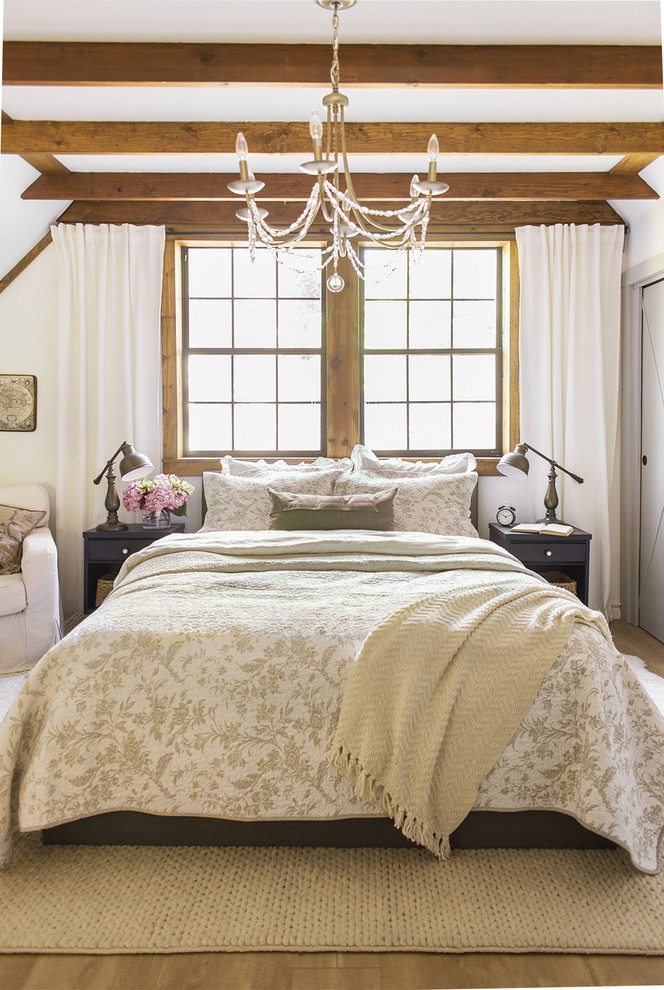 a vintage meets farmhouse bedroom with wooden beams on the ceiling, light-colored walls and some printed textiles  (Jenna Sue Design Co.)