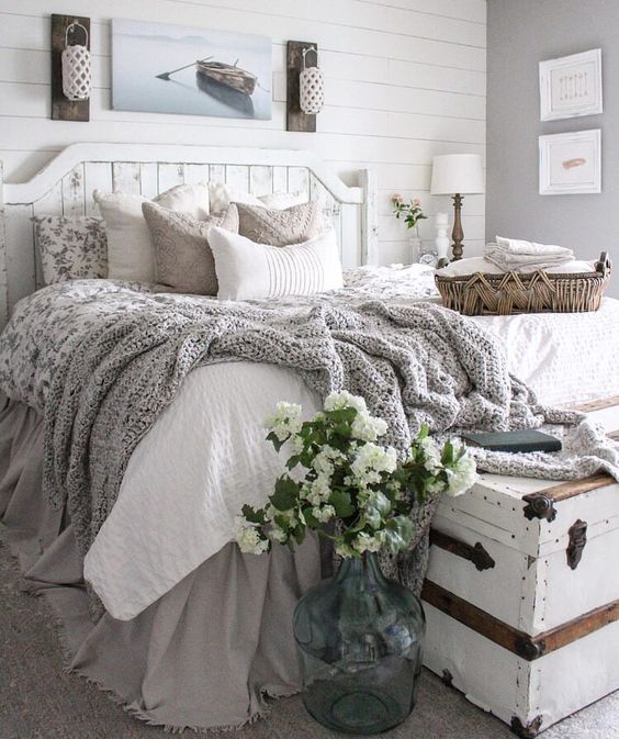 a beach farmhouse bedroom in neutrals with a whitewashed bed and walls plus a chest and cozy textiles